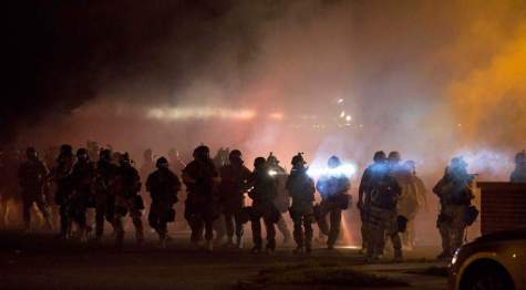 Riot police clear demonstrators from a street in Ferguson