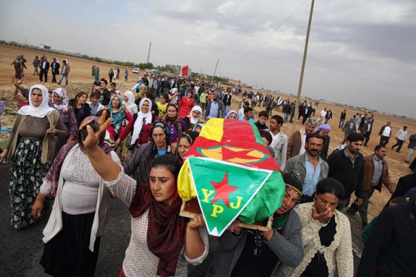 Caskets holding the bodies of four female Kurdish fighters are carried from a hospital in Suruc, Turkey, to a cemetery near the border with Syria. Andrew Quilty for The Wall Street Journal